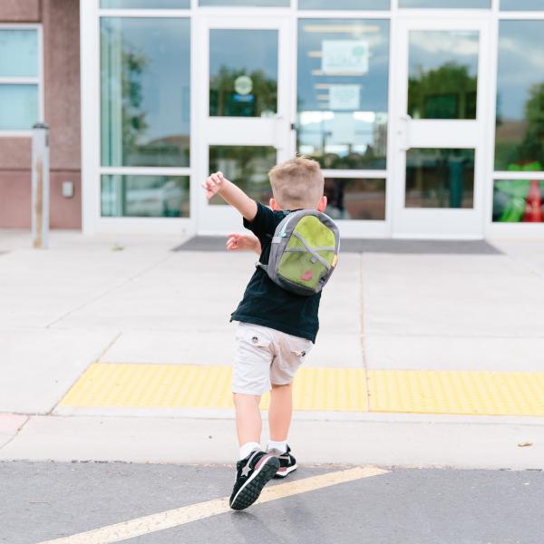 Image of boy running toward school
